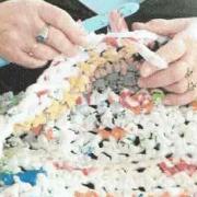 Hands crocheting the plastic bags. 