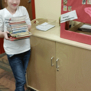 Student assistant holds a pile of books in the library