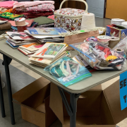 Photograph of a table labeled with Sewing and Textiles. There are sewing materials and fabric on the table.