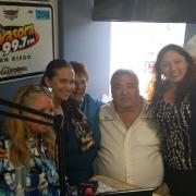 Librarians pose with a radio host after speaking about their event on air.