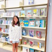 Photograph of Kid Librarian posing in front of display.