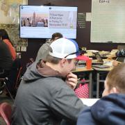 students in classroom with slide projected in background