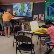 Photograph of participants painting panel art in studio.