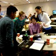 A team stands around a table while going over their ideas for Startup Weekend.