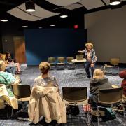 Storyteller in the middle of an audience, seated in a round