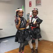 Two girls pose with their creations. 