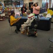 Community member showing participant how to use a  bowed psaltery. 