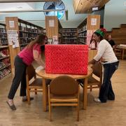 Photograph of two people at the wrapping station.