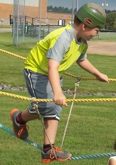 Boy climbs on tightrope.  Photo by author.