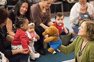 Librarian shows a puppet to a small child