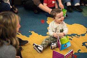 Smiling baby holds a board book