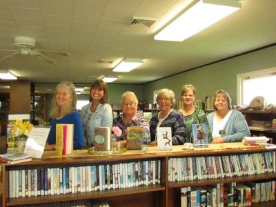 Elizabeth Berg and library staff and board members stand in the stacks