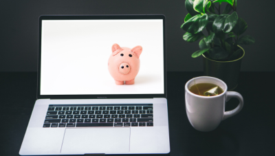 Photo of an open laptop with an image on a piggy bank on the screen