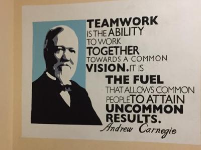 Sign that reads "teamwork is the ability to work together towards a common vision. It is the fuel that allows common people to attain uncommon results."