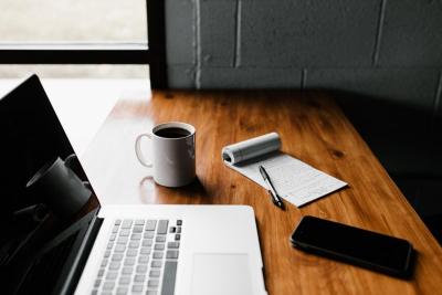 Photo of open laptop and note pad of notes.