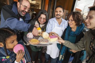 People gathered around a tray of pastries