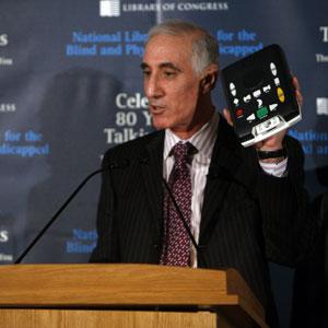 Materials Development Division chief Michael Katzmann displays an NLS digital talking book machine.