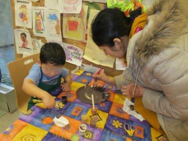 Participants blend paint colors for their paper plates self-portrait.