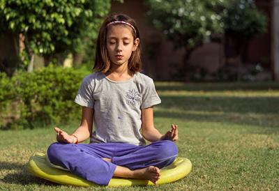 Young girl meditating outdoors