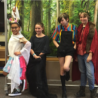 four girls pose in front of backdrop