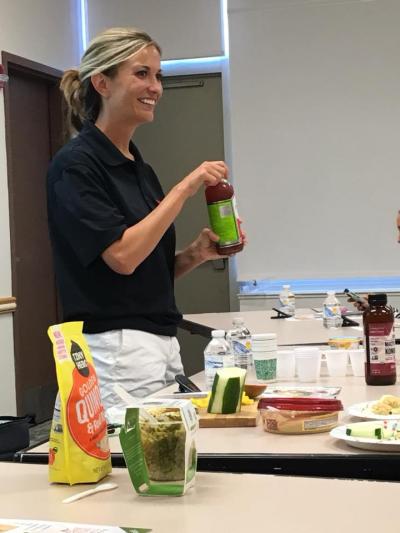 Dietitian in front of table with samples of healthy food and drink